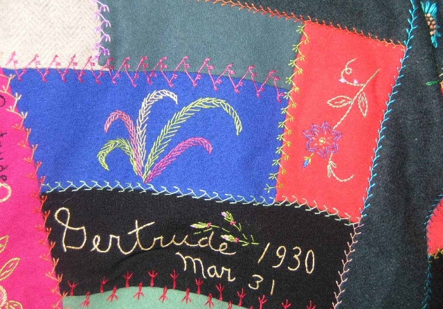 Close up of colorful quilt, with detailed stitching and the name Gertrude.
