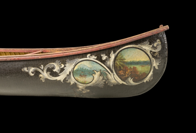 A painted canoe featuring a colorful landscape scene on its side.