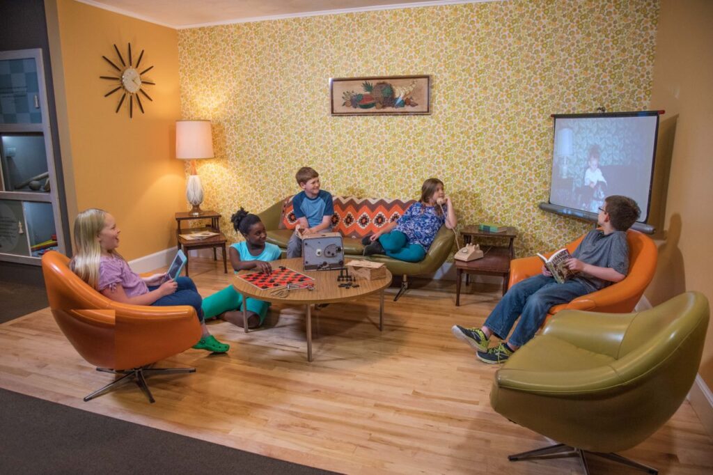 Children in 1960s living room exhibit