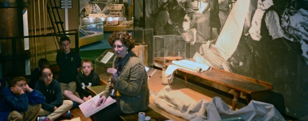 Sail making exhibit talk with children listening