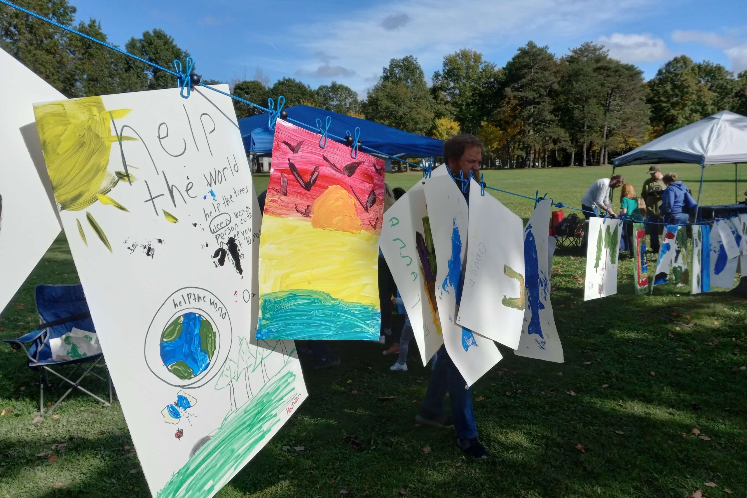 Children's artwork hanging on a clothesline.
